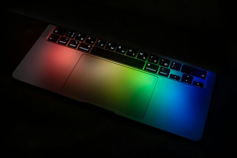 Laptop keyboard illuminated with vibrant rainbow colors, creating a stunning technology visual.